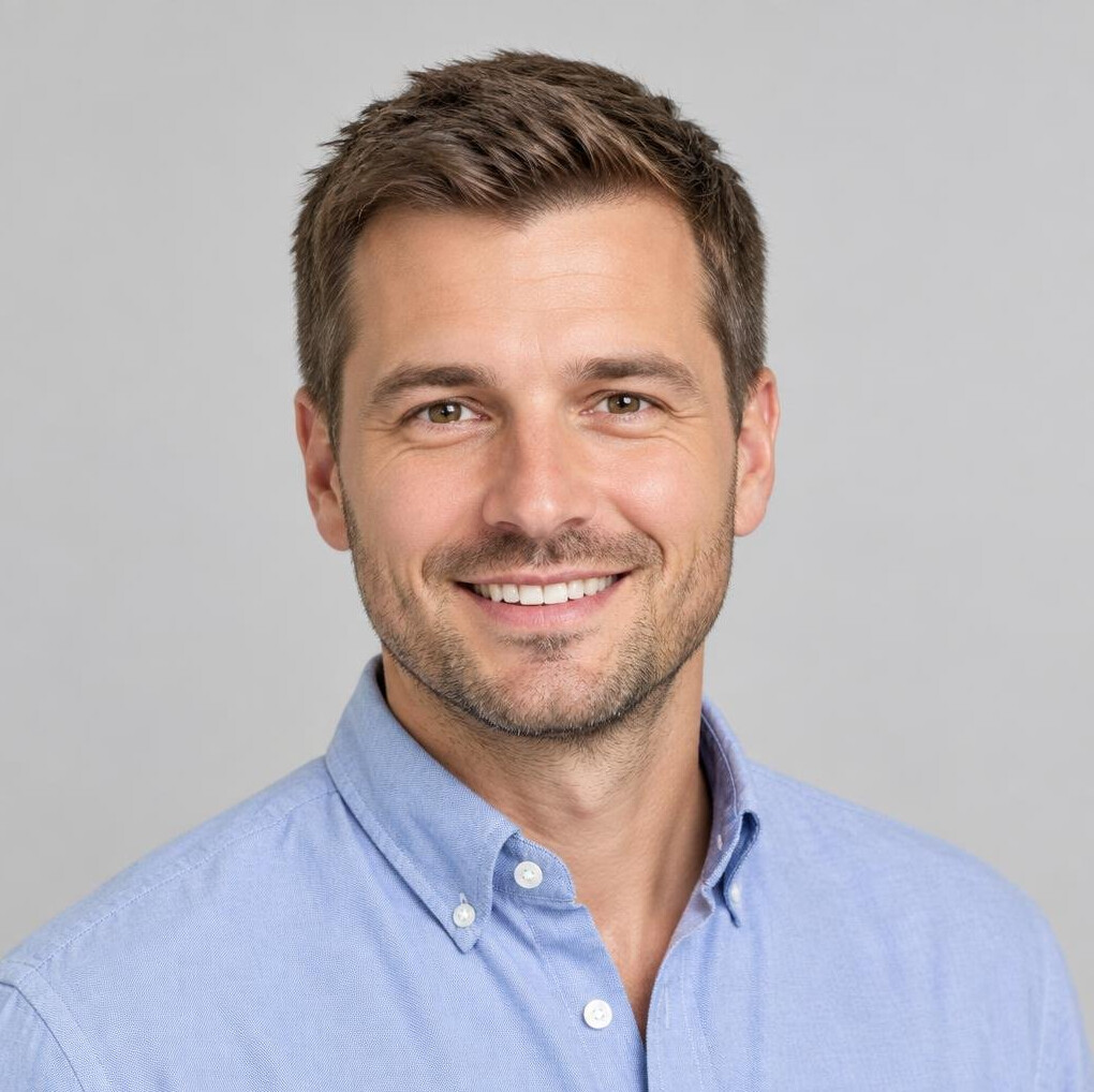 Studio portrait of a smiling Caucasian man with short hair wearing a casual shirt