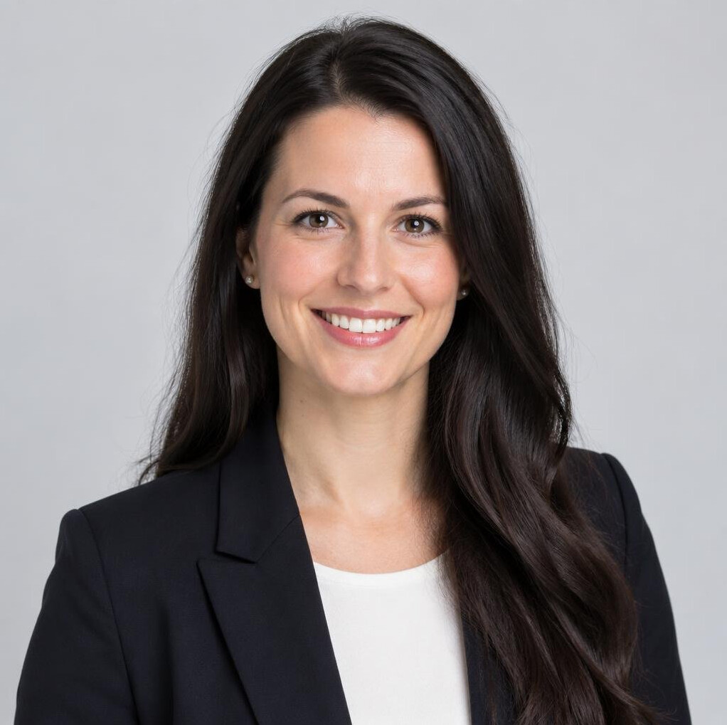 Studio portrait of a smiling woman with long dark hair wearing a blazer